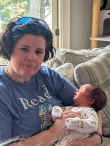 A smiling woman holding a newborn baby.